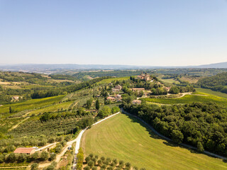 Fototapeta na wymiar Aerial/Drone Panorama of Tuscany Landscape with vineyards and olive trees - With Montauto castle and San Gimignano - Italy