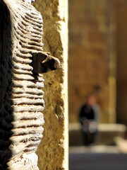 Selective focus on an old wooden door with an unrecognizable person silhouette in the background