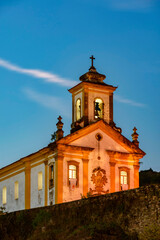 Fototapeta na wymiar Old and historic 18th century church with its facade illuminated at dusk in the city of Ouro Preto, Minas Gerais, Brazil