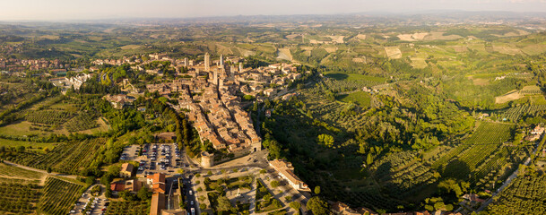 Aerial/Drone panorama of San Gimignano in the tuscany and its vineyards and olive trees that surround it, Italy  - obrazy, fototapety, plakaty