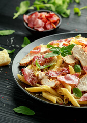 Chicken, bacon Penne pasta with parmesan cheese and basil. healthy food.