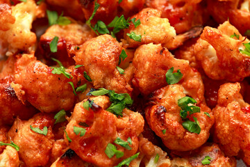 Vegan cauliflower buffalo wings on white wooden board