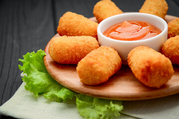 cheese nuggets with fruit sauce, on a wooden plate