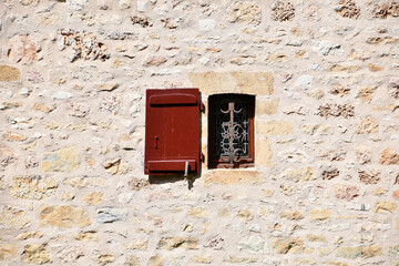An old window on a stone wall of an old village in Périgord.