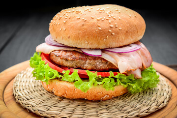 Bacon burger with beef cutlet on wooden background