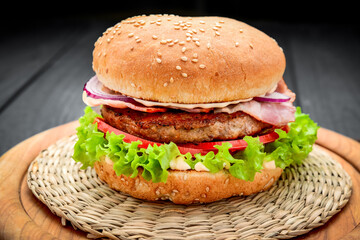 Bacon burger with beef cutlet on wooden background