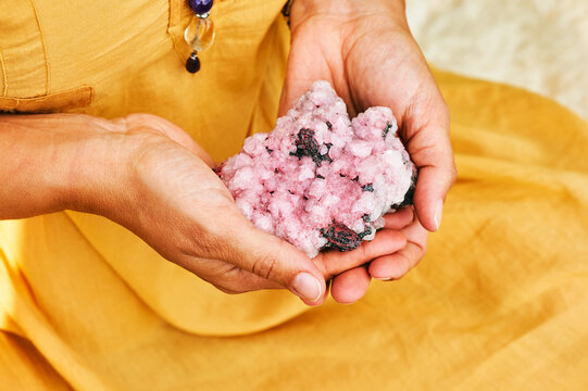 Close Up Image Of Pink Amethyst Crystal Holding By A Woman