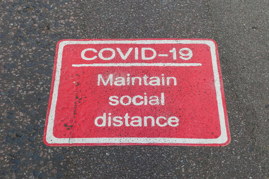 Physical Distancing Sign On Pavement