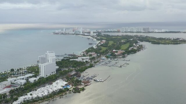 4k Aerial view of both cancuns lagoon and sea on a cludy day.
