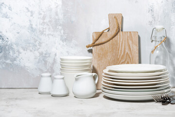 clean tableware, cutlery and kitchen utensils on white table