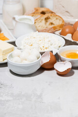fresh farm dairy products and bread on white table, vertical