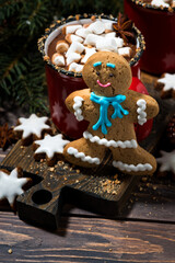 gingerbread man cookies and hot chocolate on wooden background, vertical top view