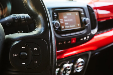 Fototapeta na wymiar Audio system and Voice dialing control buttons on steering wheel. Car interior. Shallow dof