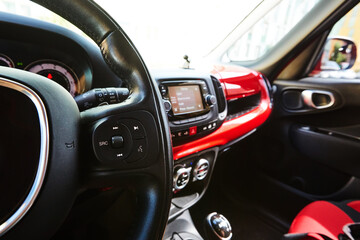 Modern black steering wheel with multifunction buttons for quick control, close-up in the car. Shallow dof.