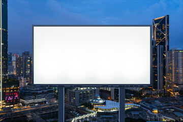 Blank white road billboard with KL cityscape background at night time. Street advertising poster, mock up, 3D rendering. Front view. The concept of marketing communication to promote or sell idea. © VideoFlow