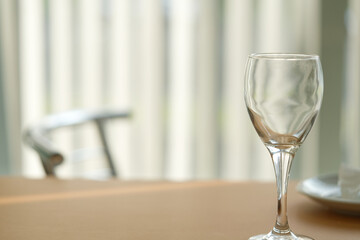 Used wine glass stays on restaurant table with heavy blurred background, shallow depth of field, selective focus