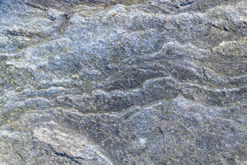 Rough, uneven, irregular granite stone surface. Natural textured relief grey background. Top view.