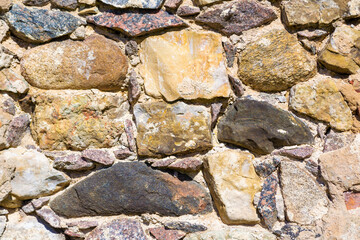 Old uneven, rough, irregular granite stone wall. Natural textured background.