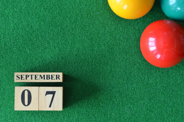 September 7, number cube with balls on snooker table, sport background.