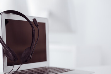 Call center and communication support, customer service help desk. VOIP headset on laptop computer