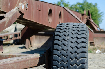 Fototapeta na wymiar Fragment of a rusty wheeled agricultural plow.