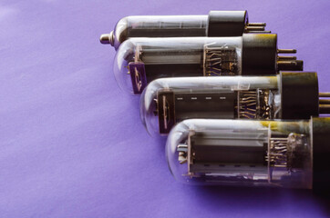 Four vacuum tubes on a blue background.