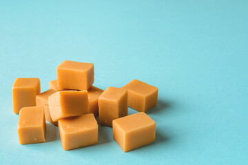 Heap of caramel vanilla fudge on a turquoise background. Fresh tasty candies made of milk and...