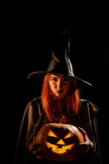 Wicked witch holding a jack-o-lantern for halloween