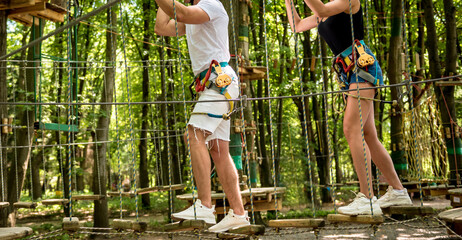 Obraz premium Young couple having fun time in adventure rope park.