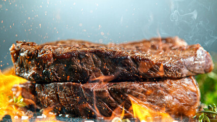 Obraz na płótnie Canvas Close-up of tasty beef steak on black stone table