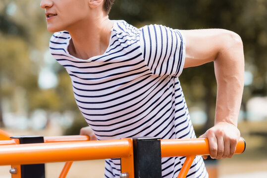 Cropped View Of Sportive Teenager Boy Exercising On Horizontal Bars