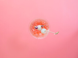 Sweet lychee liqueur on the pink background. Selective focus. Top view, copy space.