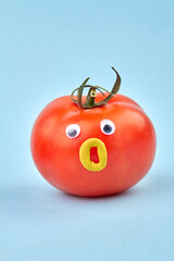 Funny humalike tomato with opened mouth. Isolated on blue background.