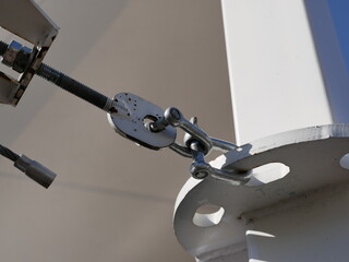 Attaching polymer fabric awnings to iron masts using steel cables, stainless steel shackles and other rigging fittings. Creating shade on the beach on a Sunny summer day.