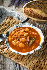 Beans with tomato sauce, bacon and sausage.