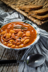 Beans with tomato sauce, bacon and sausage.