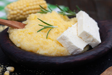 Mamaliga or polenta porridge made out of yellow maize flour. Homemade palenta with cheese, traditional meal on Balkan.