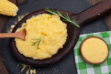 Mamaliga or polenta porridge made out of yellow maize flour. Homemade palenta in wooden bowl,...