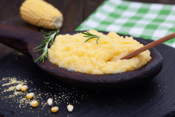 Mamaliga or polenta porridge made out of yellow maize flour. Homemade palenta in wooden bowl, traditional meal on Balkan.