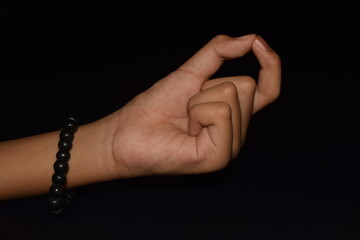 Hands in Chinmaya Mudra isolated on black background. 