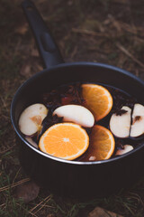 Spicy mulled wine with orange, apples, cinnamon and anise in a pot
