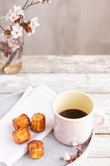 Selective focus to some pastry and cup of black coffee on plate to the wooden old table.