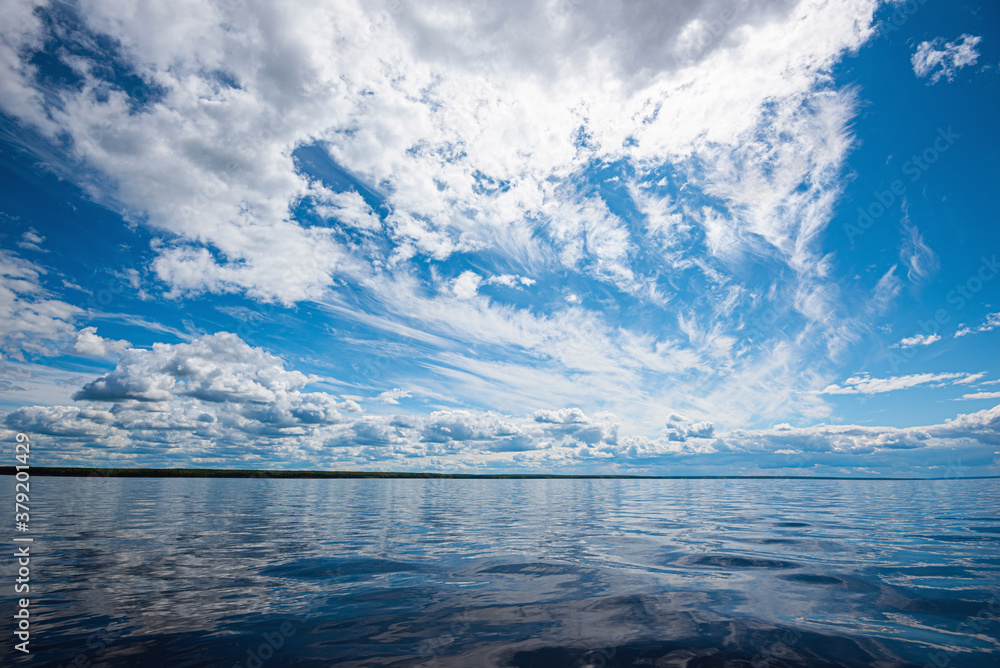 Wall mural panorama of calm lake, kama river blue sky with clouds reflected in the water.
