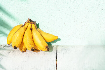 Banany na jasnym tle w świetle dziennym. © insomniafoto