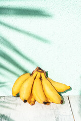 Banany na jasnym tle w świetle dziennym. © insomniafoto