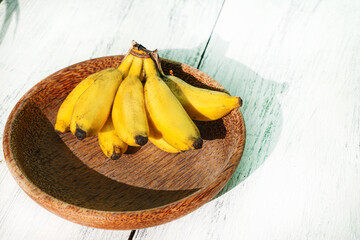Banany na jasnym tle w świetle dziennym. © insomniafoto