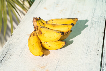 Banany na jasnym tle w świetle dziennym. © insomniafoto
