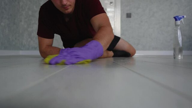 man wipes the floors in his house