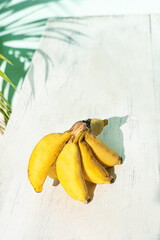 Banany na jasnym tle w świetle dziennym. © insomniafoto