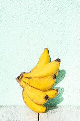 Banany na jasnym tle w świetle dziennym. © insomniafoto